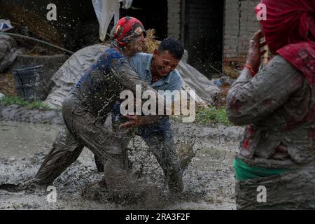 Kathmandu, Nepal. 30 giugno 2023. Il 30 giugno 2023, a Kathmandu, Nepal. I contadini nepalesi giocano in acque fangose in un campo durante le piantagioni di piantagioni di riso che segnano il "National Paddy Day" o "Ashar Pandhra". In questo giorno, i nepalesi mangiano in modo speciale yogurt mescolando riso sbattuto, cantando canzoni tradizionali, bevendo birra di riso fatta in casa e giocando in acqua fangosa mentre piantano piantine di riso nei loro campi. (Abhishek Maharjan/Sipa USA) (foto di Abhishek Maharjan/Sipa USA) credito: SIPA USA/Alamy Live News Foto Stock