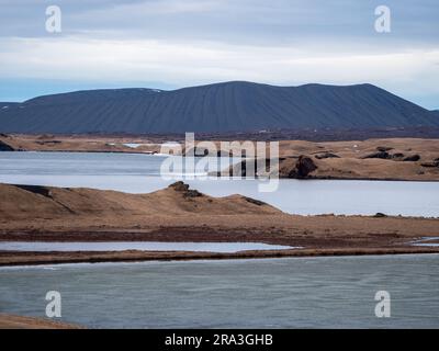 Una vista panoramica di una maestosa catena montuosa che si innalza sopra un tranquillo specchio d'acqua Foto Stock