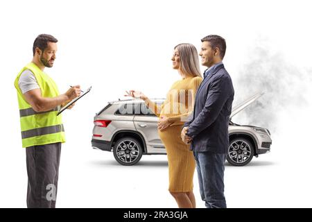 Donna incinta con suo marito che parla con un assistente stradale per un'auto rotta isolata su sfondo bianco Foto Stock