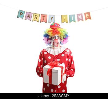 Clown in costume rosso sotto bandiere di festa con in mano una scatola regalo isolata su sfondo bianco Foto Stock