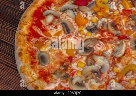 Funghi pizza: Una pizza appetitosa condita con salsa di pomodoro, formaggio fuso, funghi saporiti, peperoni vivaci e mais dolce, tutti serviti su una rus' Foto Stock