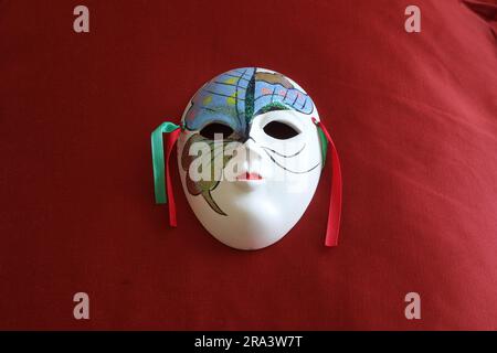 Maschera in miniatura su seta rossa Foto Stock