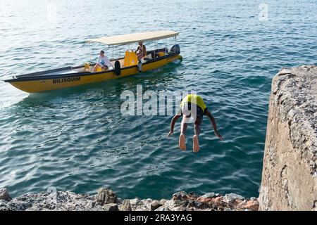Salvador, Bahia, Brasile - 14 gennaio 2022: Un giovane è visto saltare dal molo di Praia do Mam nella comunità Gamboa a Salvador, Bahia. Foto Stock