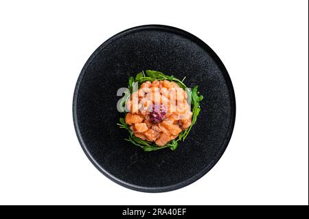 Tartare di salmone crudo o tartare con cipolla rossa, rucola e capperi in piatto nero. Isolamento di alta qualità, sfondo bianco Foto Stock