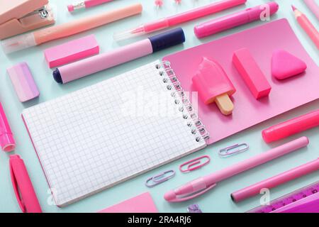 Notebook vuoto con cancelleria diversa su sfondo blu Foto Stock