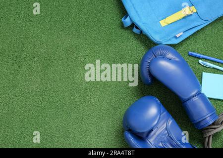 Zaino con guanti da boxe, corda salta e cancelleria su sfondo colorato Foto Stock