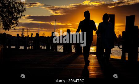 Port Macquarie, New South Wales, Australia - silhouette di due persone che camminano lungo il molo Foto Stock