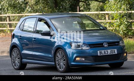 Milton Keynes, Regno Unito - 24 giugno 2023. 2013 auto blu VOLKSWAGEN POLO che viaggia su una strada di campagna inglese Foto Stock