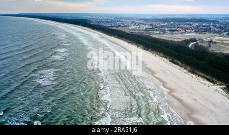 Vista aerea con un villaggio polacco dietro la foresta sul Mar Baltico in Polonia Foto Stock