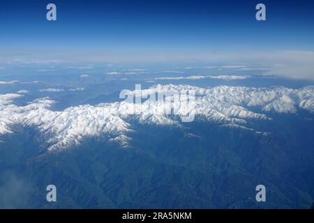 Vista panoramica delle alte cime innevate della catena caucasica principale dalla finestra di un aereo volante Foto Stock