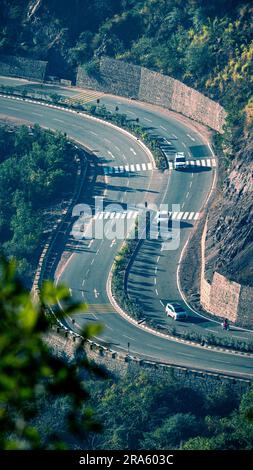 Splendida vista aerea mattutina di una lunga e tortuosa autostrada nazionale dell'Himachal Pradesh in India; viaggia su una lunga strada con bellezza paesaggistica e sole.... Foto Stock