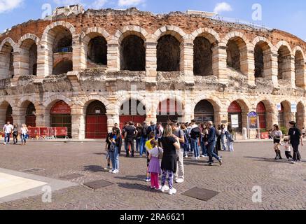 Turismo in Italia; turisti al di fuori dell'Arena di Verona, anfiteatro romano del i secolo; in primavera, sole, Piazza Bra, Verona, Veneto, Italia Europa Foto Stock