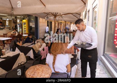 Ristorante Verona; un cameriere serve bevande ai clienti seduti all'aperto; Verona, Veneto, Italia Europa Foto Stock