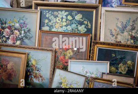 Una selezione di dipinti di fiori kitch al mercato mensile dell'antiquariato del Wembley Park, l'ultimo mercoledì del mese Foto Stock