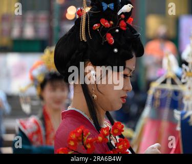 Hong Kong, Cina -- 11 marzo 2023. Una donna cinese con un'espressione pensiva indossa abiti da sposa tradizionali. Foto Stock