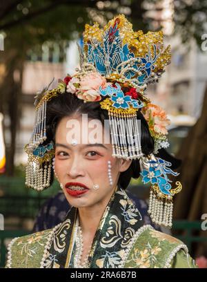 Hong Kong, Cina -- 11 marzo 2023. Ritratto di una donna cinese con bretelle e un elaborato abito da sposa con i capelli. Foto Stock