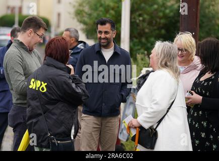 Il primo ministro Humza Yousaf mentre distribuisce volantini con il candidato SNP per le potenziali elezioni suppletive di Rutherglen e Hamilton West, Katy Loudon durante una visita a Blantyre prima di una possibile elezione suppletiva di Rutherglen e Hamilton West. Data foto: Sabato 1 luglio 2023. Foto Stock