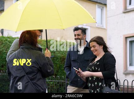 Il primo ministro Humza Yousaf mentre distribuisce volantini con il candidato SNP per le potenziali elezioni suppletive di Rutherglen e Hamilton West, Katy Loudon durante una visita a Blantyre prima di una possibile elezione suppletiva di Rutherglen e Hamilton West. Data foto: Sabato 1 luglio 2023. Foto Stock