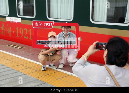 (230701) -- SHANGHAI, 1 luglio 2023 (Xinhua) -- i passeggeri posano per le foto del treno n.. Y701 che corre tra Shanghai della Cina orientale e Jiaxing della provincia di Zhejiang della Cina orientale, 30 giugno 2023. Il 25 giugno 2021, in occasione del centenario della fondazione del Partito Comunista Cinese, il No Il treno turistico Y701 "Nanhu¤1921" da Shanghai a Jiaxing è stato lanciato per la prima volta, collegando le risorse turistiche di Shanghai e Jiaxing, che sono legate alla storia fondatore e rivoluzionaria del Partito. Il treno ora effettua un viaggio di andata e ritorno una volta al giorno tra la stazione ferroviaria occidentale di Shanghai Foto Stock