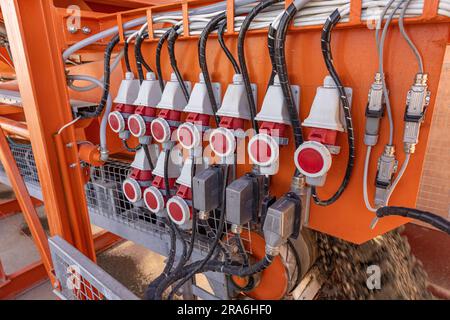 Prese industriali e spina sul quadro di distribuzione. Elettricità per cantiere, fornitura temporanea di energia Foto Stock