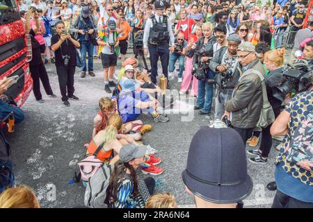 Londra, Regno Unito. 1 luglio 2023. I manifestanti si siedono e bloccano la strada durante la manifestazione. Gli attivisti Just Stop Oil della comunità LGBTQ hanno spruzzato vernice rosa e bloccato il Pride in London Parade sedendosi di fronte a un camion della Coca-Cola che partecipa alla sfilata, in segno di protesta contro la Pride che lavora con le industrie legate alla crisi climatica e in segno di protesta contro la Coca-Cola, visto come il più grande inquinatore di plastica del mondo. Credito: SOPA Images Limited/Alamy Live News Foto Stock