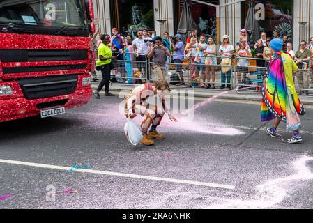 Piccadilly, Londra, Regno Unito. 1 luglio 2023. I manifestanti Just Stop Oil hanno fermato la Pride London Parade spruzzando la strada e sedendosi di fronte al galleggiante della Coca Cola. La polizia alla fine spostò i manifestanti per permettere che la parata continui Foto Stock