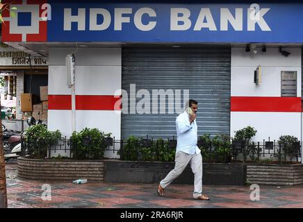 Mumbai, Maharashtra, India. 1 luglio 2023. Un uomo che parla con il cellulare passa davanti alla filiale della banca HDFC a Mumbai. Housing Development Finance Corporation (HDFC Ltd) si è fusa con la banca HDFC il 1 luglio 2023. Si prevede che la fusione creerà il quarto più grande finanziatore al mondo con una capitalizzazione di mercato di 172 miliardi di dollari. (Immagine di credito: © Ashish Vaishnav/SOPA Images via ZUMA Press Wire) SOLO USO EDITORIALE! Non per USO commerciale! Foto Stock