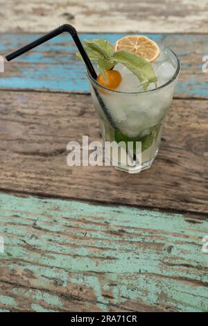 Vista dall'alto di un cocktail con una paglia decorata con frutta su un tavolo rustico in legno. Concetto bevande alcoliche Foto Stock