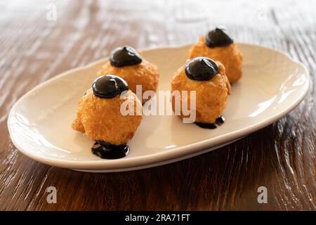 Primo piano di una tapa di piccole crocchette con inchiostro calamaro. Concetto di cucina spagnola Foto Stock