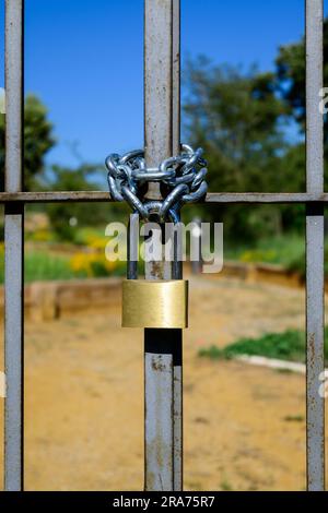 Vecchio lucchetto chiuso appeso al cancello di metallo vecchio stile Foto Stock