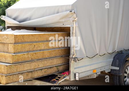 Trasporto di pannelli isolati per facciate in un rimorchio per auto. rimorchio carico. Foto Stock