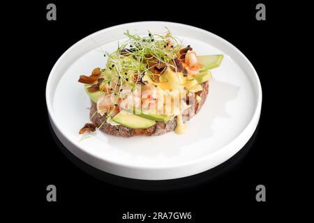 Tosta con gamberi, gamberi, avocado e uova in camicia Foto Stock