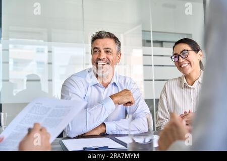 Uomini d'affari felici team dirigenziali internazionali che parlano alla riunione di gruppo. Foto Stock