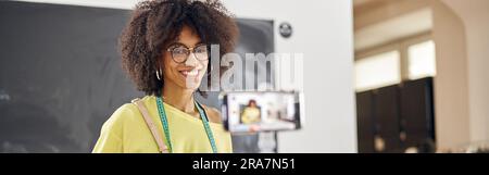 Sorridente insegnante afroamericano spara tutorial per la classe di moda a tavola Foto Stock
