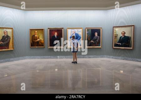 REGINA, SK, CANADA - 24 GIUGNO 2023: Un visitatore che guarda gli ex ritratti di prima qualità alla Saskatchewan Gallery all'interno della bolla legislativa del Saskatchewan Foto Stock