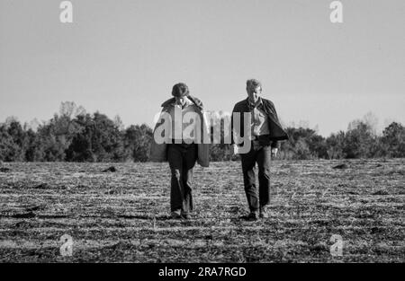 Il presidente Jimmy Carter e suo figlio, Chip Carter, camminano nei campi invernali dormienti della Carter Farm a Plains, Georgia. Il presidente era in vacanza e faceva la sua prima visita nella sua città natale dopo la sua inaugurazione. Foto di Bernard Gotfryd Foto Stock