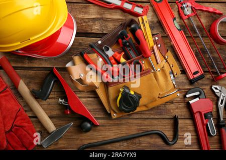 Cintura in pelle e diversi attrezzi per la riparazione su tavolo in legno, posizionamento piatto Foto Stock