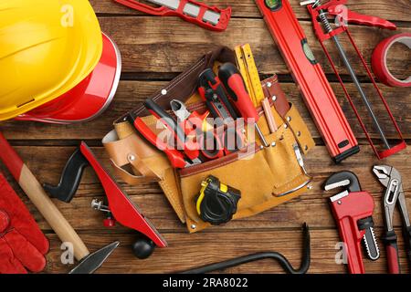 Cintura in pelle e diversi attrezzi per la riparazione su tavolo in legno, posizionamento piatto Foto Stock