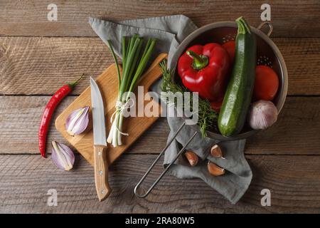 Cucinare ratatouille. Verdure, rosmarino e coltello su tavola di legno, stesa piatta Foto Stock