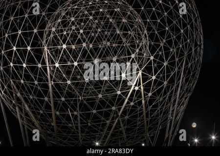 Belfast, Regno Unito. 2 luglio 2023. Full Moon a Belfast. La luna piena può essere vista attraverso la scultura d'arte pubblica RISE creata da Wolfgang Buttress. Si trova alla rotatoria di Broadway a Belfast. Crediti: Bonzo/Alamy Live News Foto Stock