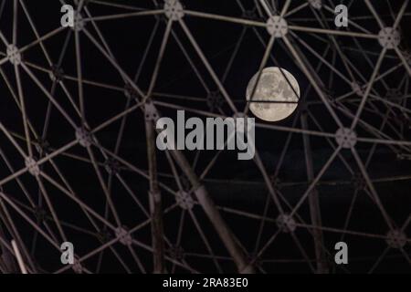 Belfast, Regno Unito. 2 luglio 2023. Full Moon a Belfast. La luna piena può essere vista attraverso la scultura d'arte pubblica RISE creata da Wolfgang Buttress. Si trova alla rotatoria di Broadway a Belfast. Crediti: Bonzo/Alamy Live News Foto Stock