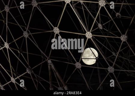 Belfast, Regno Unito. 2 luglio 2023. Full Moon a Belfast. La luna piena può essere vista attraverso la scultura d'arte pubblica RISE creata da Wolfgang Buttress. Si trova alla rotatoria di Broadway a Belfast. Crediti: Bonzo/Alamy Live News Foto Stock