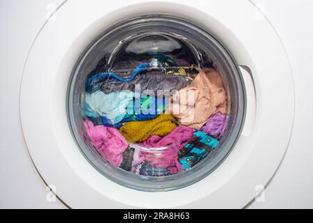 Una lavatrice con vestiti sporchi all'interno. Lavatrice moderna Foto Stock