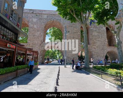 Strada e ristorante accanto all'Acquedotto di Valente, un Acquedotto romano a Istanbul, Turchia Foto Stock