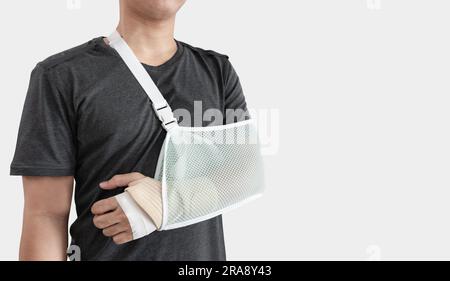 Giovane con la mano ferita, con braccio rotto e stecca, isolato su sfondo bianco Foto Stock