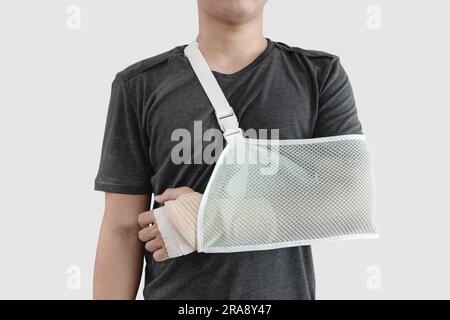 Giovane con la mano ferita, con braccio rotto e stecca, isolato su sfondo bianco Foto Stock