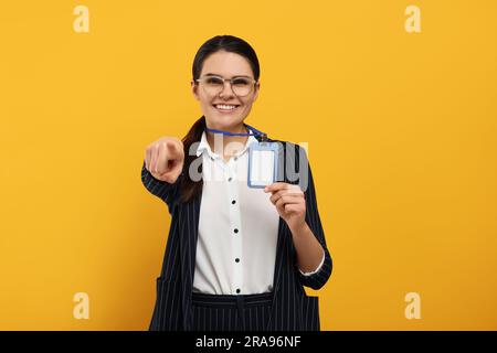 Happy Woman con badge vip Pass su sfondo arancione Foto Stock