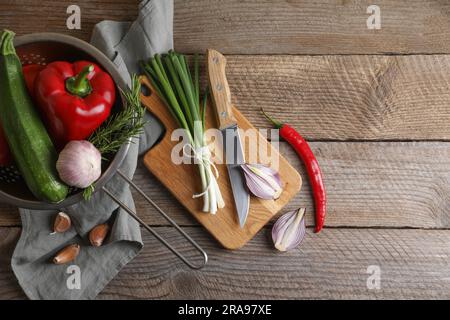 Cucinare ratatouille. Verdure, rosmarino e coltello su tavola di legno, stesa piatta Foto Stock