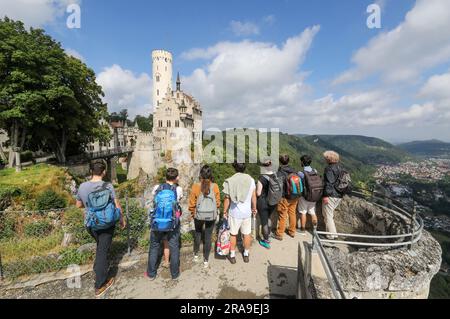 Lichtenstein, Germania. 2 luglio 2023. I turisti si trovano su una piattaforma panoramica e si affacciano sul castello di Lichtenstein nell'Alb Svevo. Crediti: Thomas Warnack/dpa/Alamy Live News Foto Stock