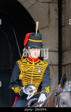 Soldato femmina del Re della truppa cavallo Royal Artillery in guardia in sfilata delle Guardie a Cavallo, Whitehall, Londra, vestito in uniforme. Soldato montato con la spada Foto Stock